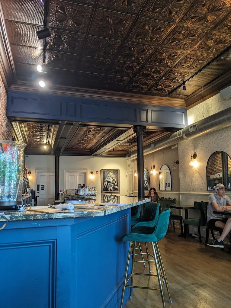 Interior view with ornate tin ceiling and emerald bar stools